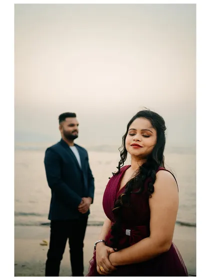 A serene portrait of the bride-to-be on the beach, with her partner in the background. This style of shot tells a story.