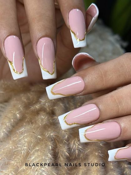 This is an abstract French design on long, square nails. It features a modern, edgy twist with a crisp white tip and a hand-painted gold chrome border for a futuristic and bold statement.