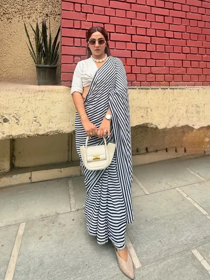 A great wardrobe is full of pieces you can re-wear. This striped saree from my own bridal trousseau gets a modern twist with a white shirt as a blouse and statement pearls. I believe in investing in classics and restyling them for a fresh, new-age look.