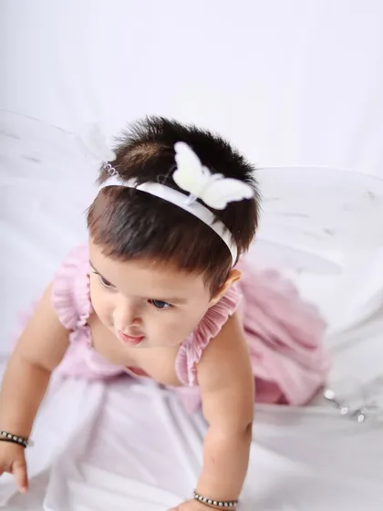 This little fairy in a pink dress and butterfly wings is on the move, capturing a moment of exploration and curiosity.