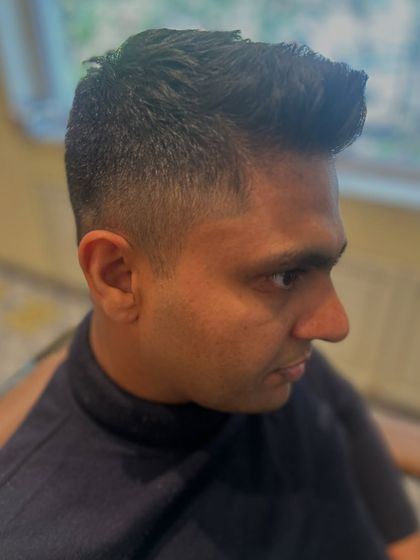 Another angle of this sharp fade, showing the texture and volume on top. This is a versatile cut that can be styled neatly or worn a bit messier.