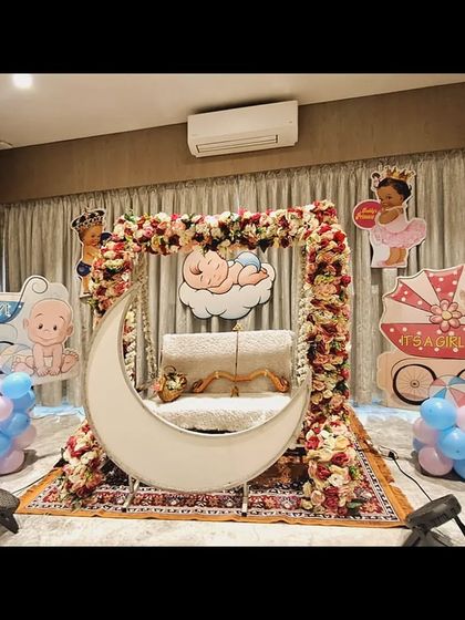 A clear, bright shot of the home baby shower decor, highlighting the floral work and the cute baby-themed cutouts.