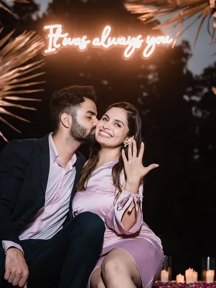 A sweet kiss on the cheek, capturing the love and happiness of the moment. The neon sign adds a modern, romantic touch.