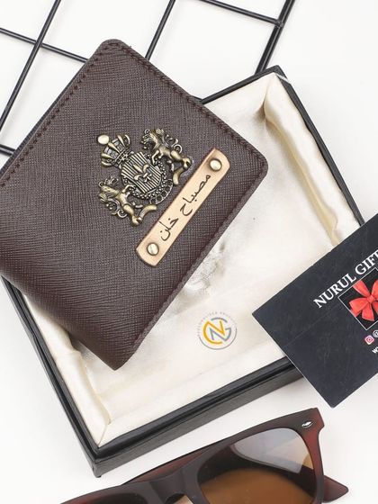 A personalized brown wallet with a royal crest charm, elegantly presented in its gift box.
