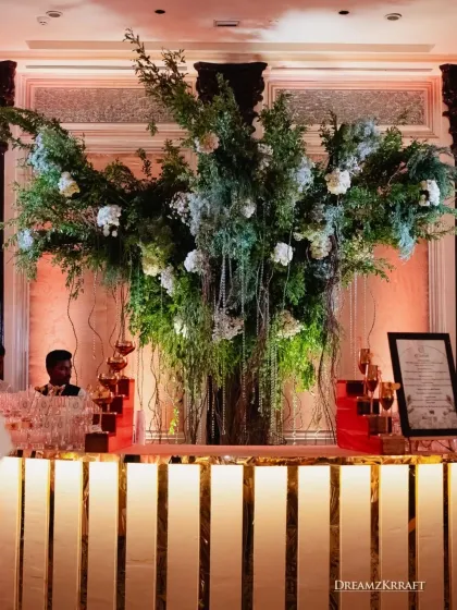 A stunning floral installation cascades over a modern, illuminated bar. I design functional areas like bars to be beautiful statement pieces that integrate seamlessly into the overall decor.