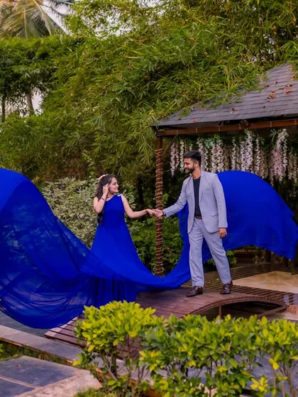 A couple with a flowing blue gown on the wooden bridge, a classic and stunning pre-wedding photo.