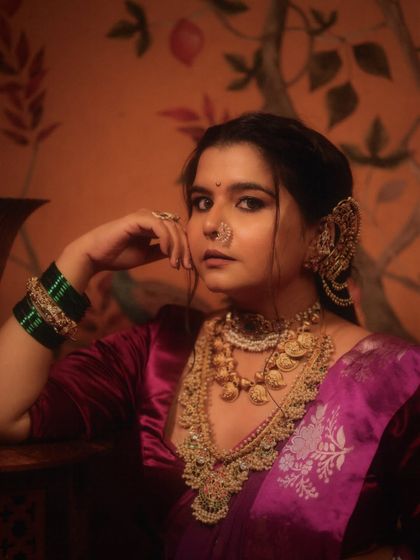 A powerful and poised portrait. The makeup is bold yet refined, designed to enhance her features and complement the grandeur of the traditional attire and heavy jewelry.