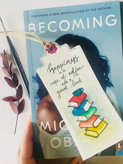 Another one of our hand-painted watercolor bookmarks, this one featuring a stack of books and the quote "Happiness is a cup of coffee and a good book."