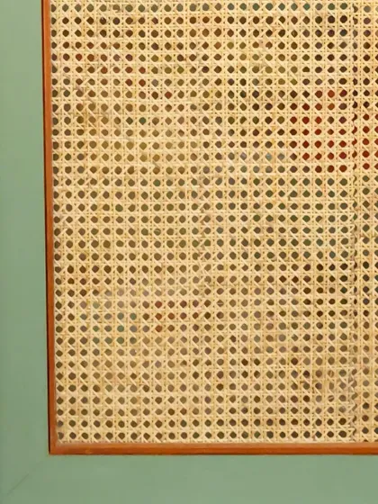 A close-up detail of the wardrobe's cane sheet, sandwiched between glass and a ply frame for durability and a clean finish.