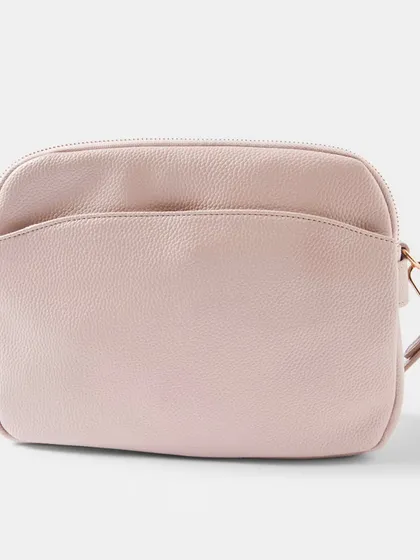 The Australia Crossbody bag in a soft, dusty pink colour. The rose gold hardware adds a warm, feminine touch to the design.