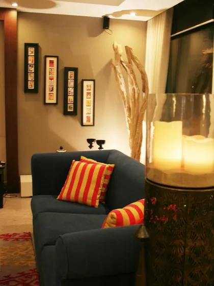 Creating a cosy corner is all about thoughtful home styling. Here, I used warm lighting from the large candle holder, contrasting striped cushions on the deep blue sofa, and curated wall art to make this little nook feel intimate and personal. It shows how even small changes can completely transform the mood of a space.