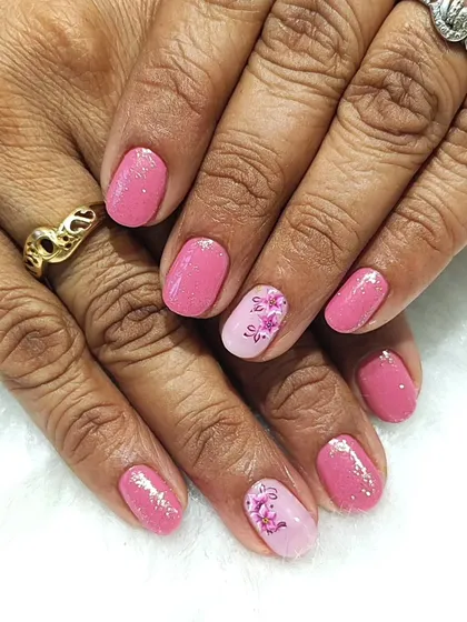 Pretty in pink with a floral touch. This design on short nails features a shimmery pink gel polish with a delicate, hand-painted floral accent nail.