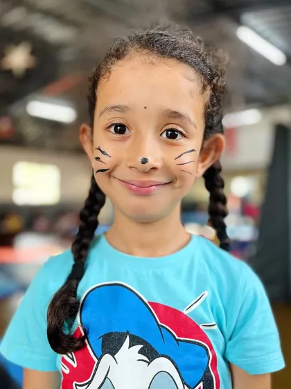 Getting creative with some face paint. This little one's cat whiskers and sweet smile are guaranteed to make you feel "pawsitive".