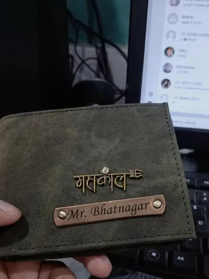 A personalized denim wallet in olive green, featuring a 'Mahakal' charm and a 'Mr.' nameplate, perfect for someone with a spiritual side.