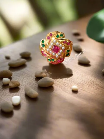 An aesthetic shot of the 'Sia' adjustable ring. This piece showcases the beauty of Jadau craftsmanship with its vibrant stones and delicate pearl detailing, designed to fit any finger.