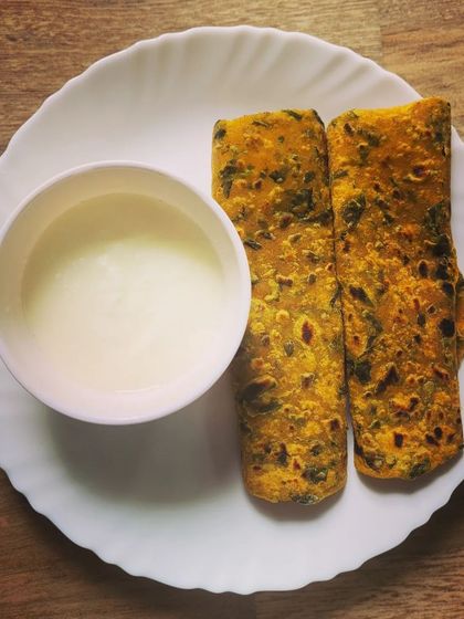 Healthy and delicious Methi Parathas, made with fresh fenugreek leaves and whole wheat flour. They are perfect for breakfast or lunch, served here with a bowl of plain yogurt.