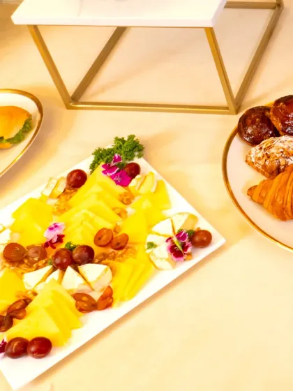A high-tea setup for our collaboration with L'Opéra. The spread includes a cheese platter, fresh croissants, and other French pastries, creating a Parisian experience for guests.