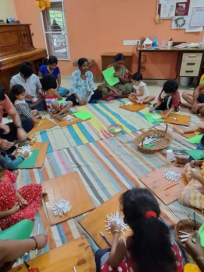 Another angle of the flower craft workshop, showing parents and children creating side by side.
