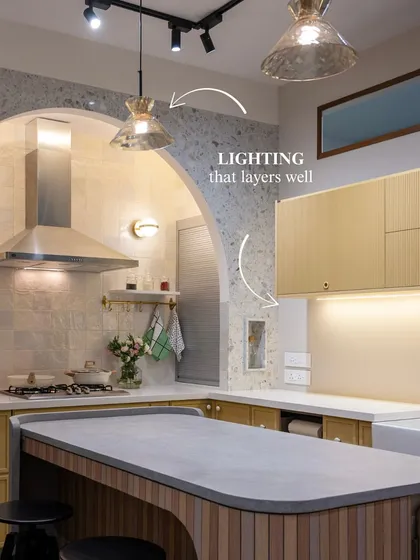 The layered lighting in this kitchen, from the pendant lamps to the under-cabinet strips and the sconces within the arch, creates a warm and inviting ambiance. Good lighting is essential for both function and mood.