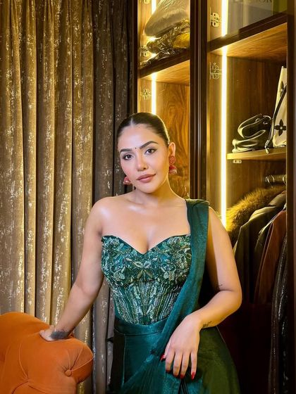 A confident pose showing off the full effect of the festive glam. The emerald green outfit is perfectly complemented by the warm, glowing makeup.