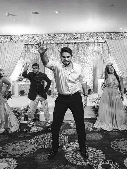 The reception is where everyone lets loose, and we’re right there on the dance floor to capture the energy. This black and white shot freezes a high-energy dance performance, focusing on the movement and joy of the celebration without distraction.