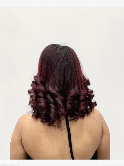 The back view of the red-toned hair with defined curls, showing the even color application and the beautiful shape of the style.