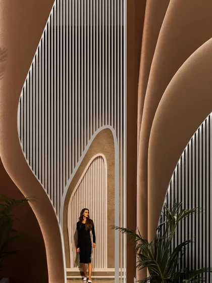 A view from within the "Water & Wind" residence, looking out through the fluid, organic openings that frame the exterior spaces.
