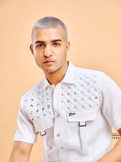 The power of a clean white shirt. This one features a unique woven texture and buckle details, elevating a classic piece.