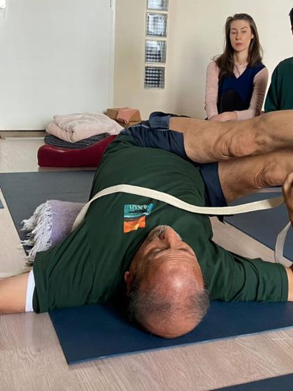 A supported bridge pose with a strap.