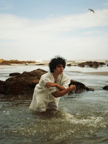 This series showcases a male model interacting with the natural beach environment. From the water to the rocks, each shot captures a different mood, perfect for an editorial story.