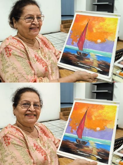 A smiling student proudly presents her vibrant painting of a sailboat at sunset, showcasing the beautiful colors and reflections she learned to create.