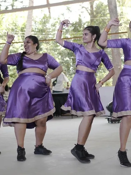 This crew's coordinated purple outfits and joyful expressions light up the stage.