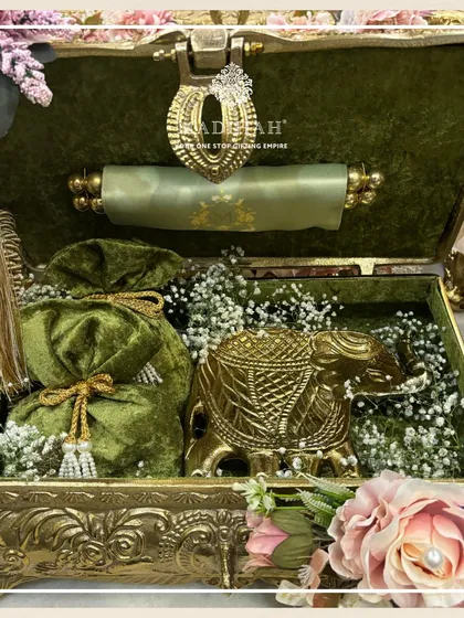 This Rajwada Chest in olive green velvet is filled with regal treasures, including a golden elephant figurine and matching potli. It’s a perfect example of how I customize hampers to match a wedding's color theme.