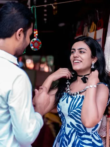 Her happy reaction as she tries on a necklace. This candid shot is full of life and captures a genuine moment of joy.