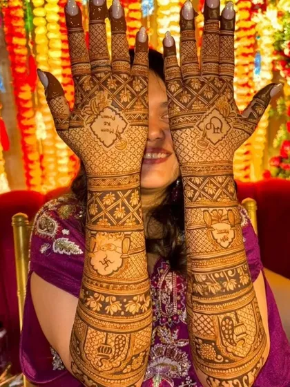 A full view of a detailed bridal mehendi, featuring auspicious symbols like the swastika and kalash, along with personalized initials for the couple.