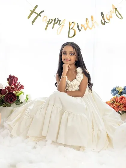 A thoughtful pose from the birthday girl in her beautiful white dress, creating a classic and timeless portrait.