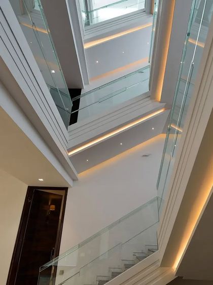 Looking down through a multi-level stairwell, where strategic lighting accentuates the clean geometry and creates a dramatic sense of depth.