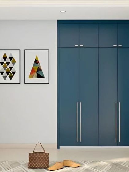 A minimalist yet bold wardrobe design in a deep blue. The clean lines and simple silver handles create a modern look, while the full-height doors offer ample storage space.
