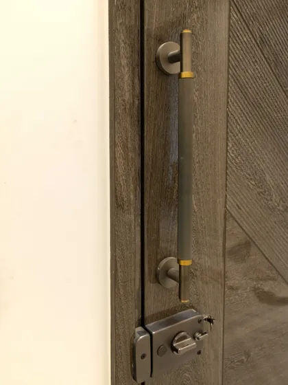 The right hardware completes the look. This custom handle on a grey veneer door adds a touch of industrial chic, perfectly matching the door's modern aesthetic.