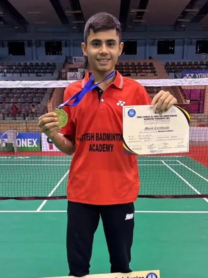 A proud moment for the academy as Dev poses with his gold medal and merit certificate. We focus on creating national-level badminton champions.