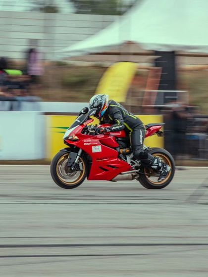 A close-up action shot of the red Ducati, front wheel slightly lifted, showcasing the rider's control and the bike's immense power.