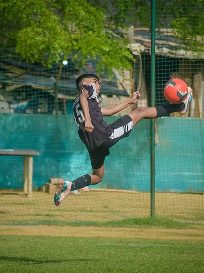 It's all about skill and agility. Here, one of our young athletes executes a perfect aerial kick during a competitive Pride Cup match, showing the high level of technique we teach.