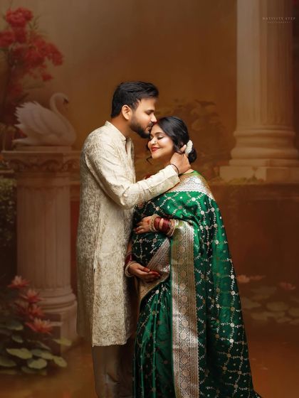 A gentle and loving pose between the couple, dressed in beautiful ethnic wear. The husband's tender touch on his wife's head conveys care and affection.