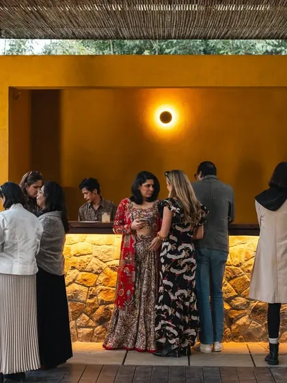 Guests mingle at the bar during the 'Breathing Room' event we hosted with Soho House. Our poolside bar, with its natural stone front, serves as a social hub for gatherings.