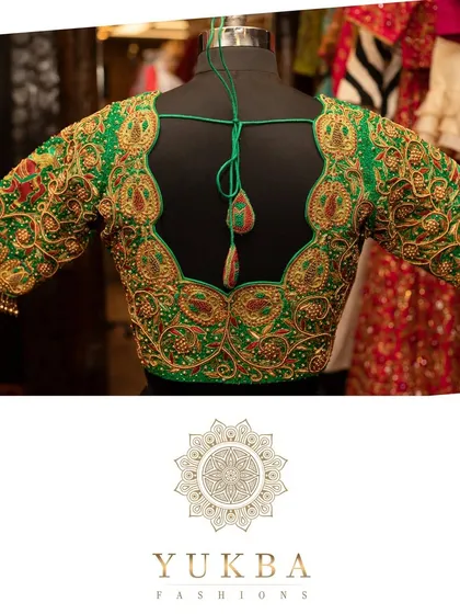A heavily worked green bridal blouse with a deep U-back. The design is rich with gold zardosi and beadwork, creating a luxurious and traditional feel.