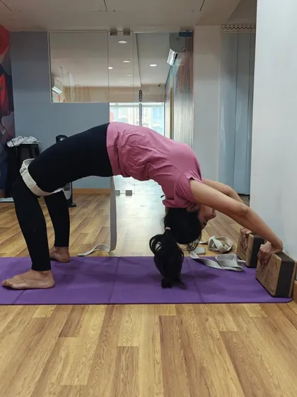 This is an advanced variation of Chakrasana using both blocks and a strap. The strap helps stabilize the arms, allowing for a deeper and more controlled opening of the shoulders and heart.