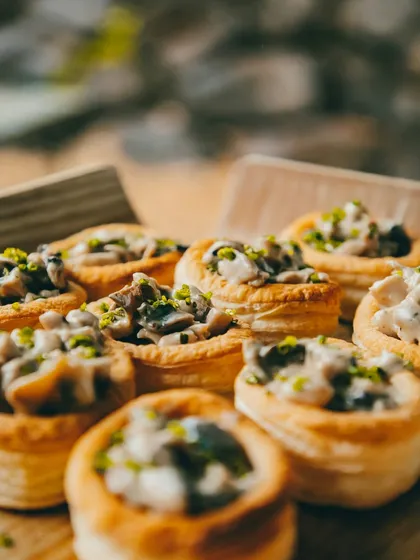 We take pride in our gourmet vegetarian offerings. This close-up shows our Creamy Mushroom Vol-au-vents, a sophisticated bite-sized appetizer filled with a rich, savory mushroom filling, perfect for adding a touch of elegance.