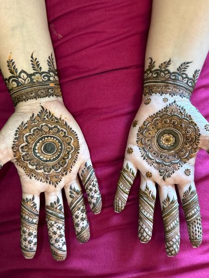 A classic mandala design on the palm, with simple and elegant line work extending down the fingers.