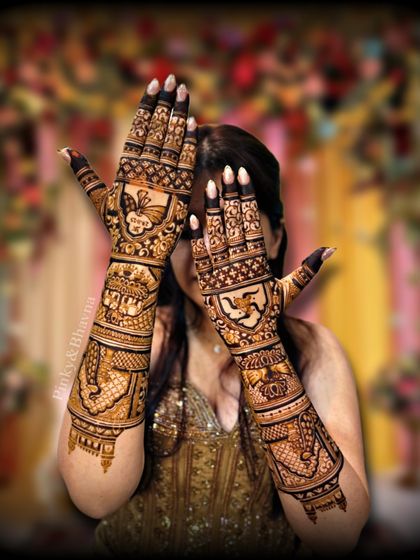 A beautiful shot of the bride with her full wedding mehndi. The design includes traditional figures and patterns, creating a rich and celebratory look perfect for her special day.