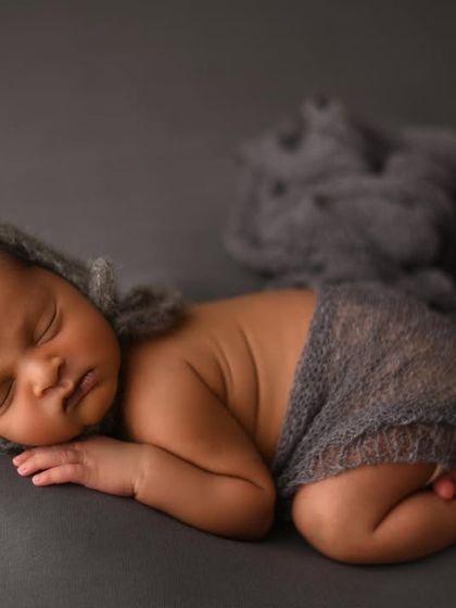 This side-laying pose is perfect for showing off a newborn's profile and cute little bottom. I used a simple grey bonnet and wrap to create a modern, minimalist look for this baby boy's portrait.